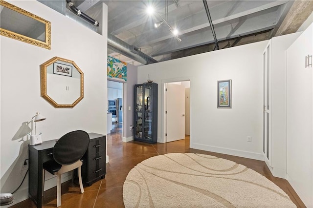 interior space with baseboards, visible vents, and a high ceiling