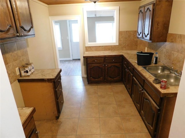 306 W Kansas St, Pittsburg, KS 66762 - kitchen featuring a sink, light countertops, dark brown cabinets, backsplash, and light tile patterned flooring