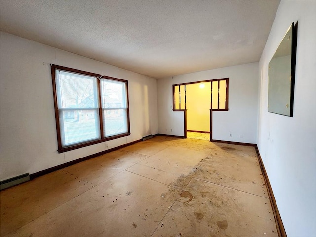 empty room featuring baseboards and a textured ceiling