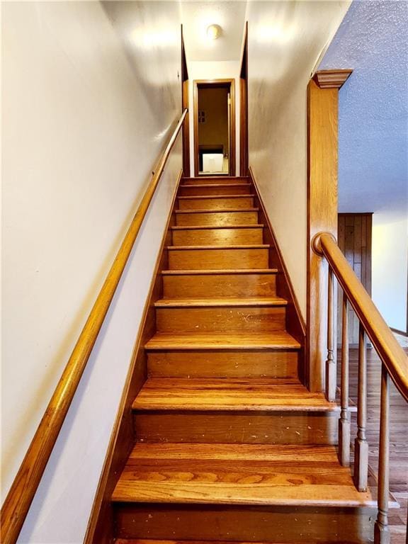 stairs featuring a textured ceiling