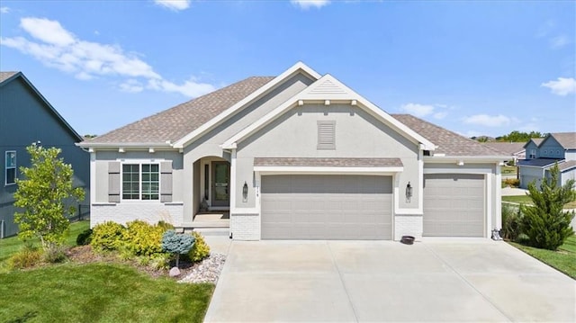 view of front of home with a garage, driveway, brick siding, a front yard, and stucco siding