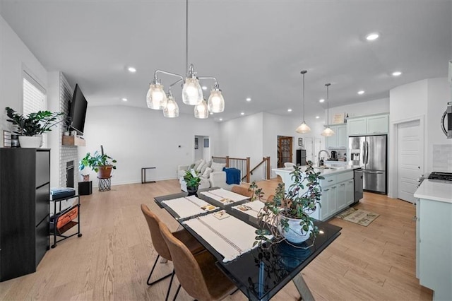 dining space featuring light wood-style flooring, a fireplace, baseboards, and recessed lighting