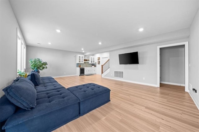 living room with recessed lighting, visible vents, and light wood-style flooring