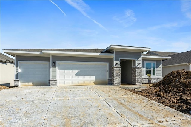 prairie-style house with stone siding, driveway, and an attached garage