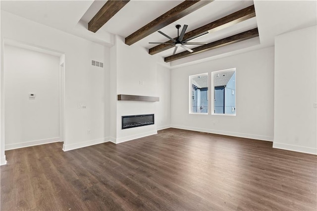 unfurnished living room featuring baseboards, visible vents, dark wood-style flooring, and a glass covered fireplace