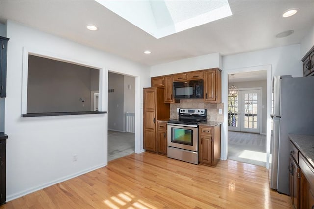 kitchen with recessed lighting, light wood-style floors, appliances with stainless steel finishes, tasteful backsplash, and brown cabinetry