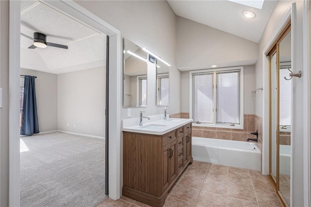 bathroom featuring vaulted ceiling, a sink, a bath, and a ceiling fan