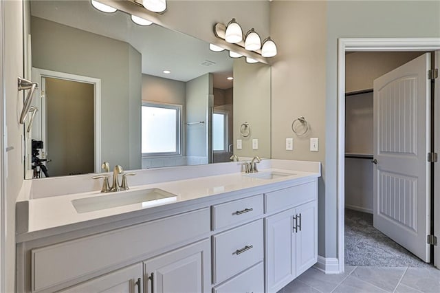 bathroom featuring double vanity, tile patterned flooring, visible vents, and a sink