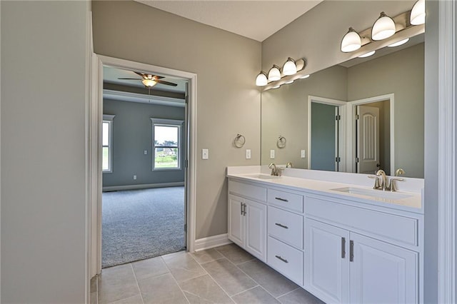 full bath featuring double vanity, tile patterned flooring, a ceiling fan, and a sink