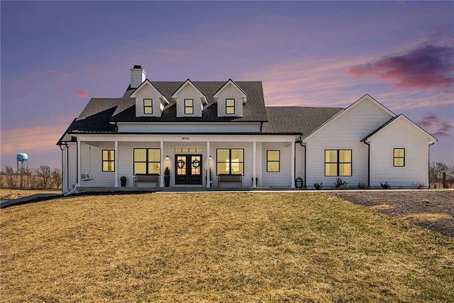 modern inspired farmhouse with a porch, french doors, and a front yard