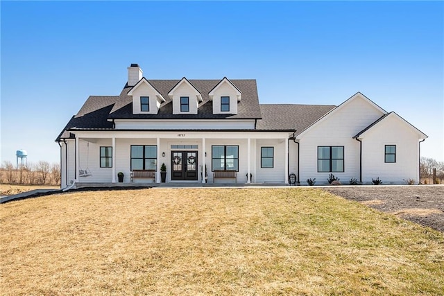 modern farmhouse style home featuring french doors, a porch, and a front lawn