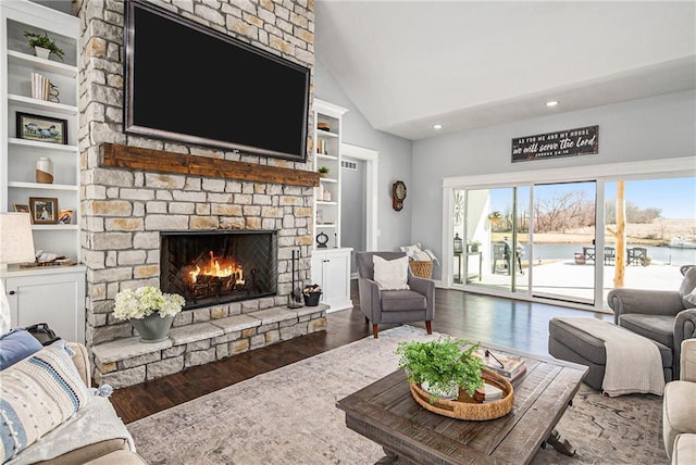 living area featuring a fireplace, high vaulted ceiling, built in shelves, and wood finished floors