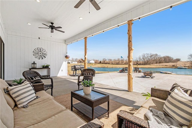 view of patio featuring a water view, ceiling fan, and an outdoor hangout area