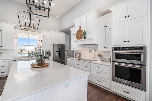 kitchen featuring decorative backsplash, white cabinets, and appliances with stainless steel finishes