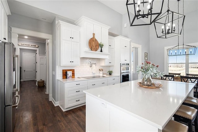 kitchen featuring white cabinetry, tasteful backsplash, appliances with stainless steel finishes, and light countertops