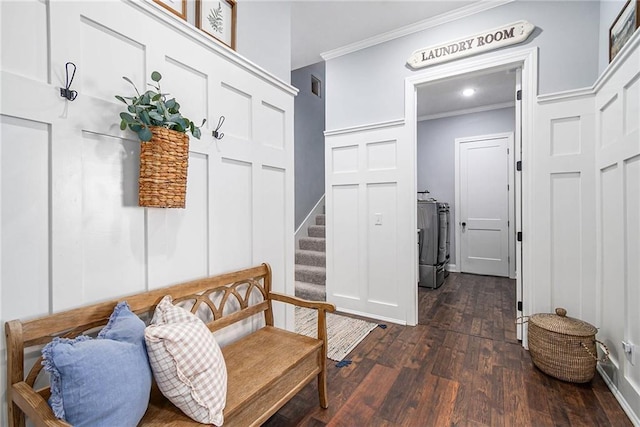 mudroom featuring visible vents, dark wood-type flooring, washing machine and dryer, and ornamental molding