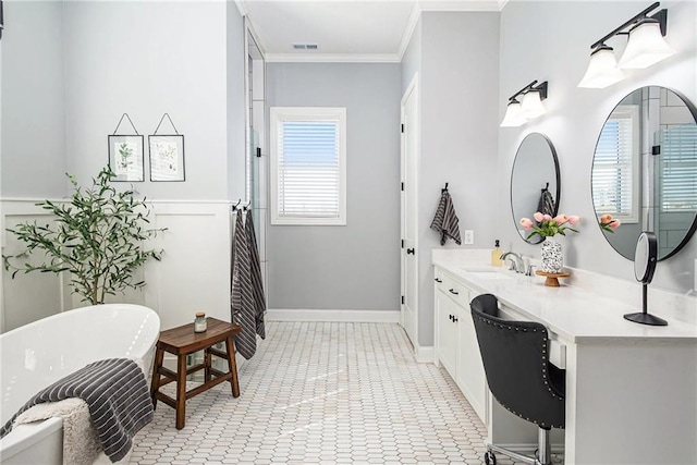 full bathroom with vanity, baseboards, visible vents, a freestanding bath, and crown molding