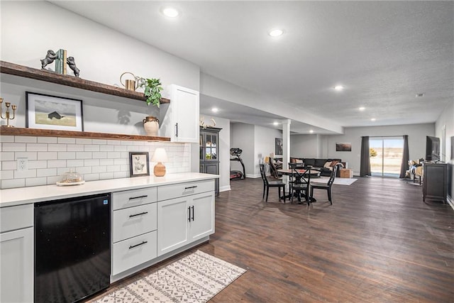 kitchen featuring dark wood finished floors, open floor plan, light countertops, refrigerator, and open shelves