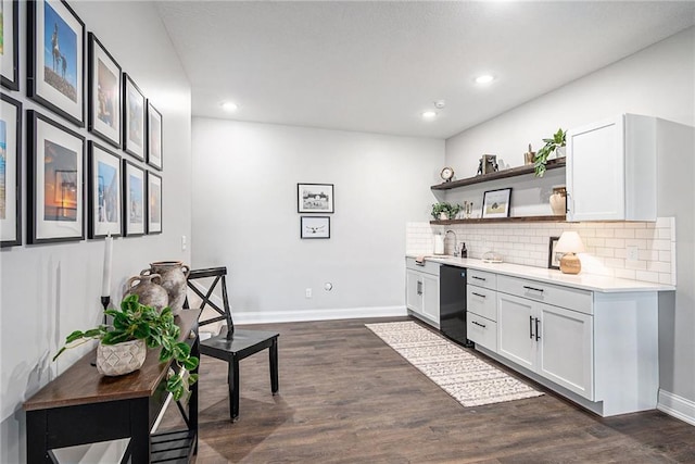 bar with tasteful backsplash, dark wood finished floors, and baseboards