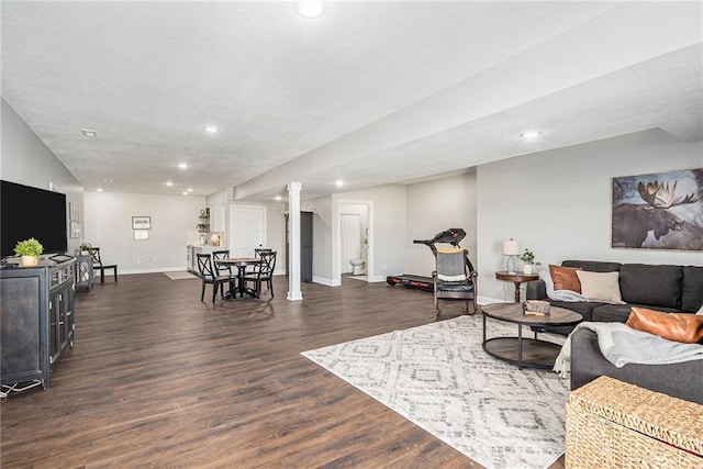 living room with recessed lighting, dark wood-style floors, baseboards, and a textured ceiling