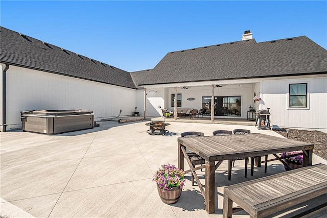 view of patio / terrace with a fire pit, a hot tub, and ceiling fan