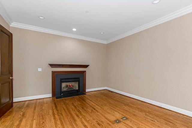 unfurnished living room featuring baseboards, a fireplace with flush hearth, recessed lighting, ornamental molding, and light wood-style floors