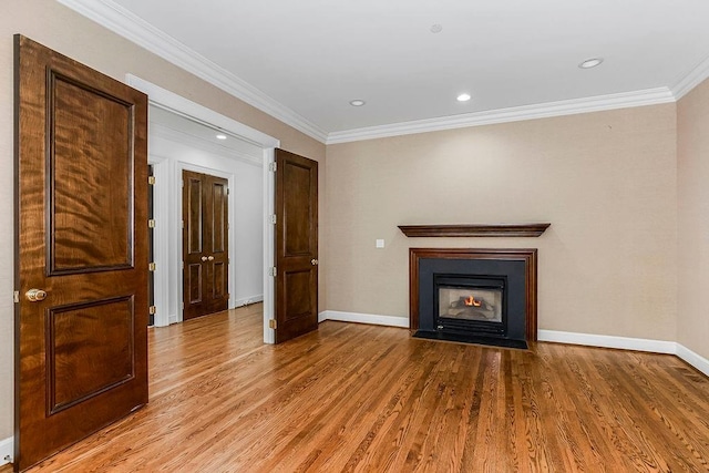 unfurnished living room featuring crown molding, a fireplace with flush hearth, baseboards, and light wood-type flooring