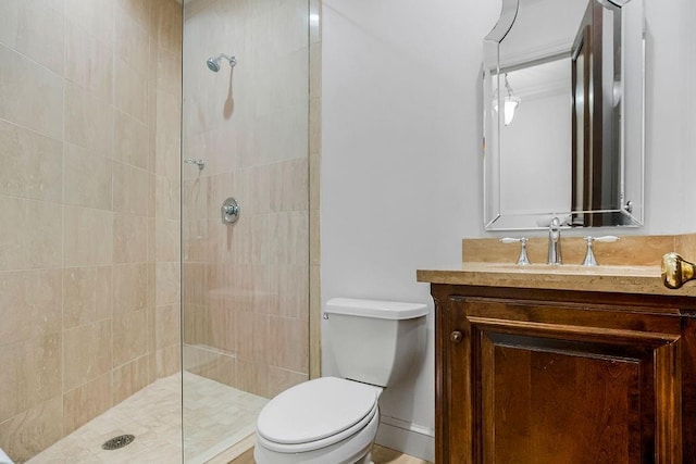 full bathroom with a tile shower, toilet, and vanity