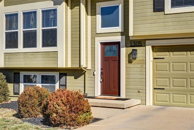 entrance to property featuring a garage and concrete driveway