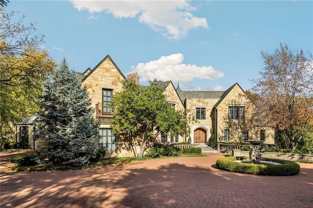 view of front of home featuring stone siding and decorative driveway