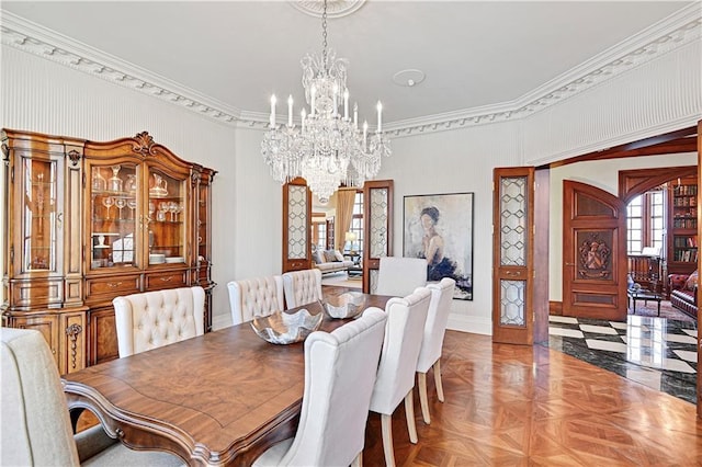 dining area with an inviting chandelier, baseboards, arched walkways, and crown molding