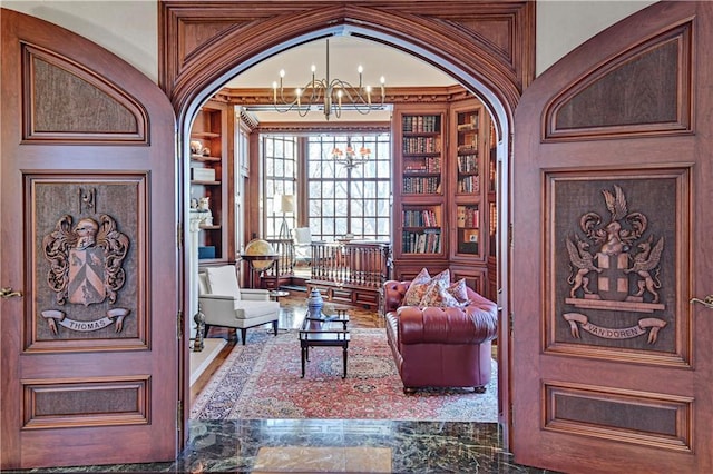 living area with built in shelves and an inviting chandelier