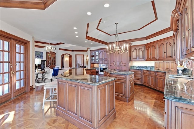 kitchen featuring a notable chandelier, a sink, stainless steel oven, a center island, and a kitchen bar