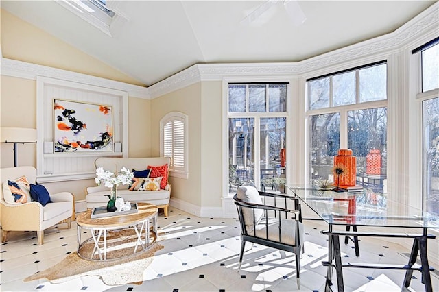 living area with vaulted ceiling, ceiling fan, and baseboards