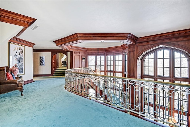 hall featuring carpet floors, a wealth of natural light, visible vents, and crown molding