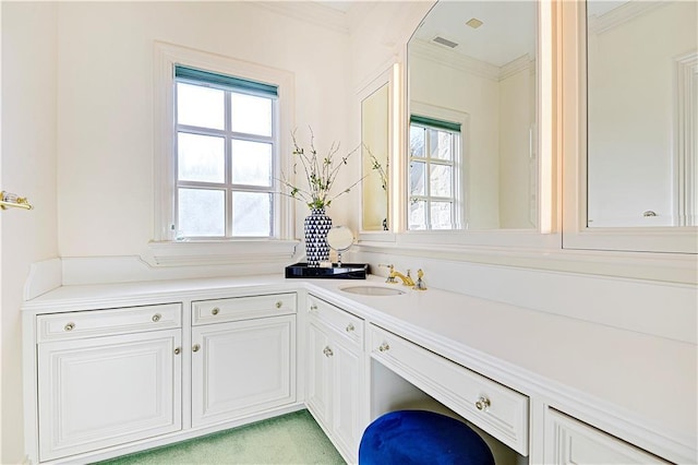 kitchen featuring crown molding, light countertops, visible vents, white cabinetry, and a sink