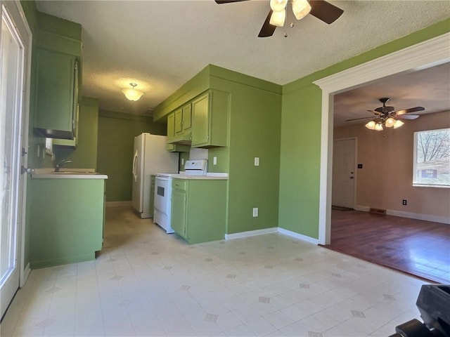 kitchen with white electric range oven, baseboards, green cabinetry, light countertops, and a textured ceiling