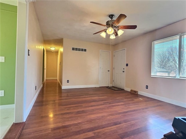 unfurnished living room featuring visible vents, baseboards, wood finished floors, and a ceiling fan