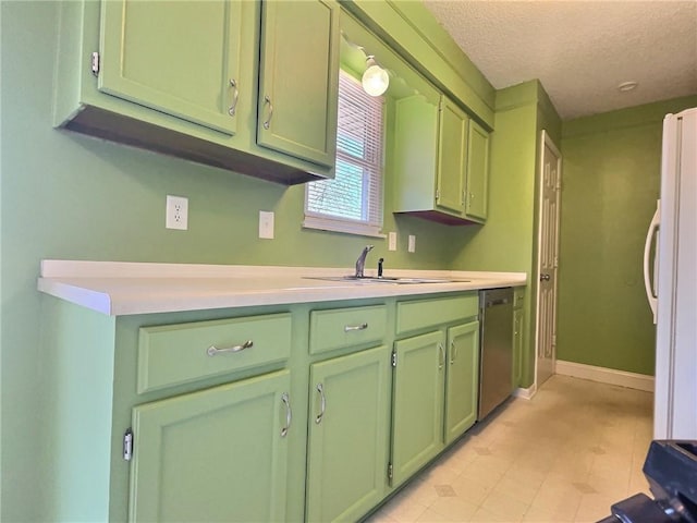 kitchen featuring green cabinetry, dishwasher, light countertops, freestanding refrigerator, and a sink