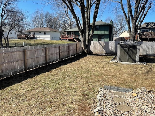 view of yard with a storage unit, an outbuilding, and a fenced backyard