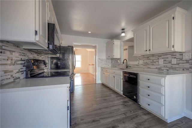 kitchen with black appliances, dark wood-style flooring, a sink, and white cabinetry