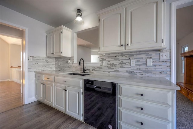 kitchen featuring light countertops, backsplash, white cabinets, a sink, and dishwasher