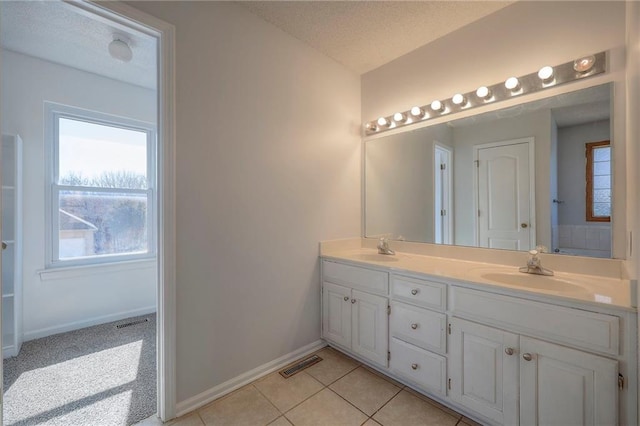 full bath featuring a textured ceiling, a sink, and visible vents