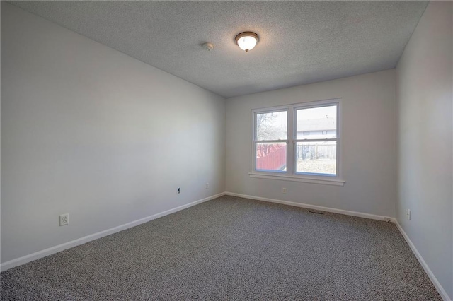 unfurnished room with a textured ceiling, carpet, and baseboards