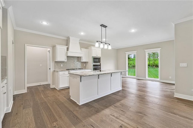 kitchen with stainless steel appliances, white cabinets, backsplash, and custom exhaust hood