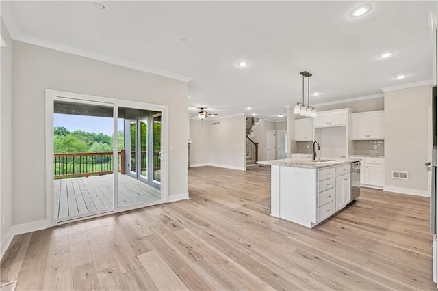 kitchen with crown molding, visible vents, a sink, and white cabinetry