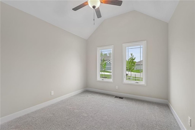 carpeted empty room featuring baseboards, visible vents, vaulted ceiling, and a ceiling fan