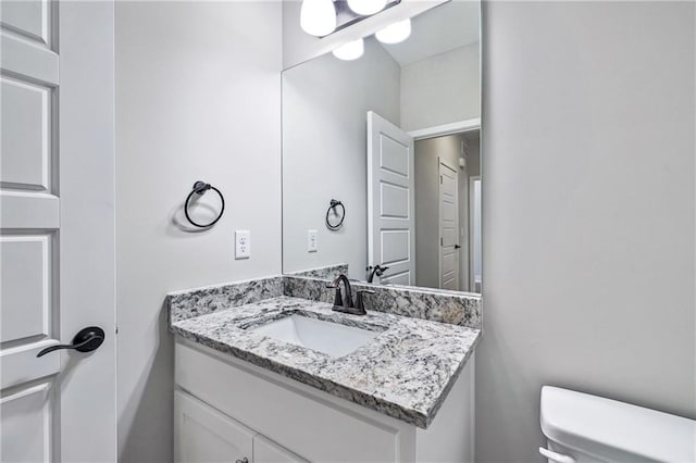 half bathroom with toilet and vanity