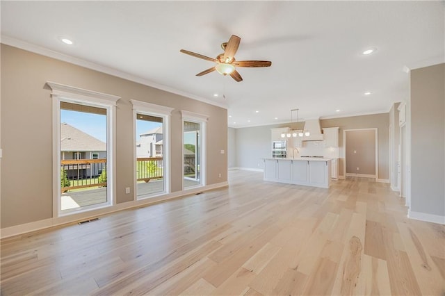 7009 NE 103rd St, Kansas City, MO 64156 - unfurnished living room with light wood-type flooring, ornamental molding, a ceiling fan, and recessed lighting