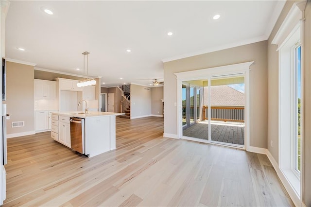 7009 NE 103rd St, Kansas City, MO 64156 - kitchen featuring stainless steel dishwasher, ornamental molding, open floor plan, a ceiling fan, and a center island with sink